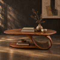 Oval coffee table with a low oval shelf and a single scroll support, three-quarter view showing the grain