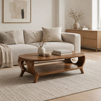 Oval coffee table with a lower shelf and flared legs with circular cutouts in a Scandinavian living room with white walls