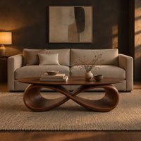 Oval coffee table with a sculpted infinity loop base in a dark living room at golden hour