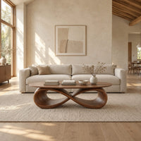 Oval coffee table with a sculpted infinity loop base in a bright open plan living room