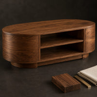 Corner detail of oval coffee table with two open shelves and curved drum ends beside wood, brass and linen samples