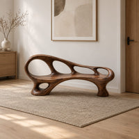 Long wooden bench with oval cutouts along the back rail and a flowing frame in a Scandinavian entryway with white walls