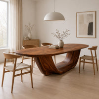 Oval dining table on a U shaped sculpted pedestal base in a Scandinavian dining room with white walls