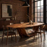 Oval dining table on a U shaped sculpted pedestal base in an industrial loft dining room with exposed brick
