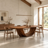 Oval dining table on a U shaped sculpted pedestal base in a bright open plan dining room