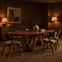 Oval dining table on a sculpted open base shaped like a w in an evening dining room with walnut wall paneling