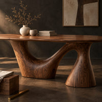 Corner detail of oval dining table on a sweeping arm base and a tall cone column beside wood, brass and linen samples