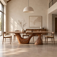 Oval dining table on a sweeping arm base and a tall cone column in a bright open plan dining room