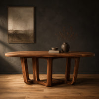 Oval dining table with sculpted arched legs joined by a low floor loop in a dark studio against a charcoal plaster wall