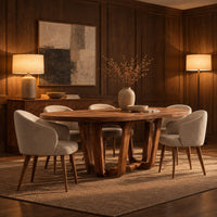 Oval dining table with sculpted arched legs joined by a low floor loop in an evening dining room with walnut wall paneling