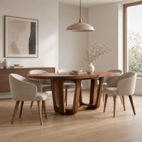 Oval dining table with sculpted arched legs joined by a low floor loop in a Scandinavian dining room with white walls