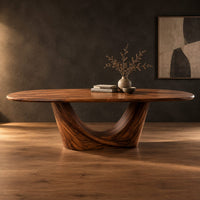 Oval dining table on a sculpted crescent base in a dark studio against a charcoal plaster wall