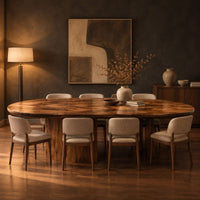 Oval dining table with a thick edge and two broad slab legs in a dark dining room at golden hour