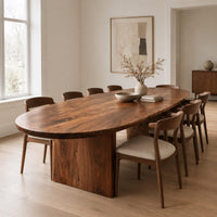 Oval dining table with a thick edge and two broad slab legs in a Scandinavian dining room with white walls