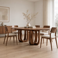 Oval dining table on two pedestal bases with tall arched openings in a Scandinavian dining room with white walls