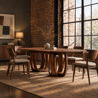 Oval dining table on two pedestal bases with tall arched openings in an industrial loft dining room with exposed brick