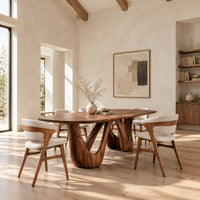 Oval dining table with two sculpted arch pedestals in a bright open plan dining room