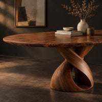 Corner detail of oval dining table with a twisting ribbon pedestal and a hollow center beside wood, brass and linen samples