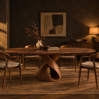 Oval dining table with a twisting ribbon pedestal and a hollow center in a dark dining room at golden hour