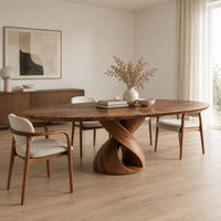 Oval dining table with a twisting ribbon pedestal and a hollow center in a Scandinavian dining room with white walls