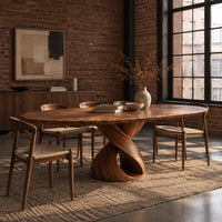 Oval dining table with a twisting ribbon pedestal and a hollow center in an industrial loft dining room with exposed brick