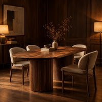 Oval dining table with two fluted cylinder bases in an evening dining room with walnut wall paneling