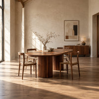 Oval dining table with two fluted cylinder bases in a bright open plan dining room