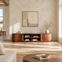 Oval ended tv stand with four open cubbies between two end cabinets in a bright open plan living room