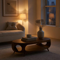 Oval porthole coffee table with a low shelf in an evening room lit by two lamps