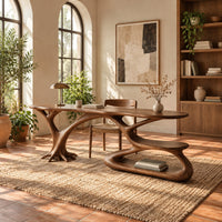 Oval top desk on branching legs with a low loop tier in a bright home office with arched windows and plants