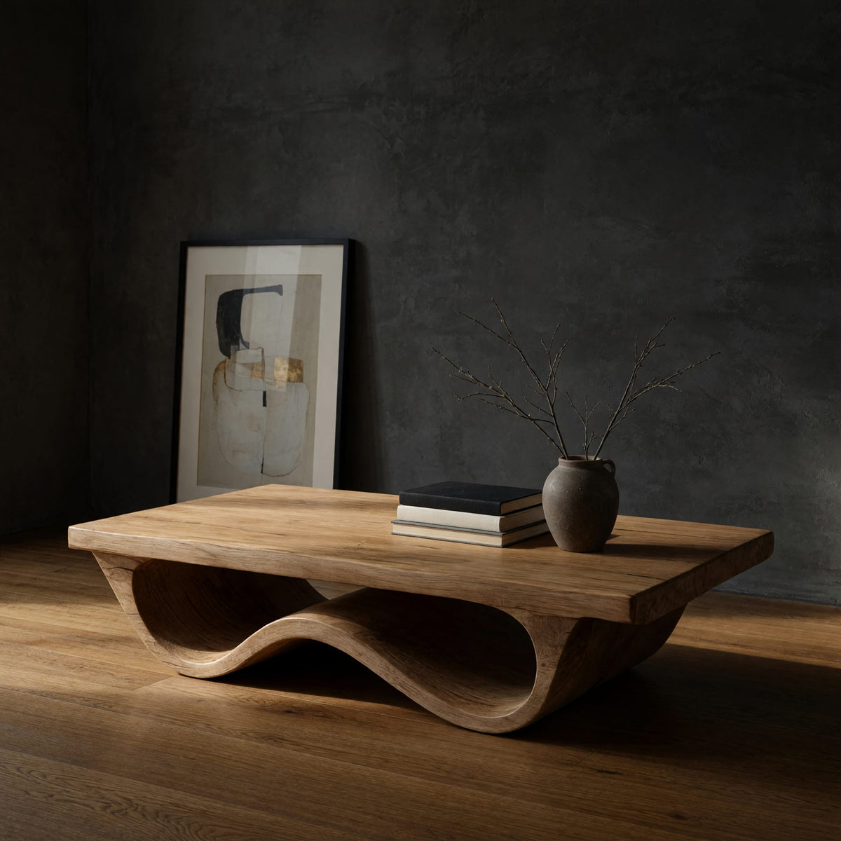 Pale hardwood coffee table with an undulating base in a dark studio against a charcoal wall