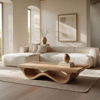 Pale hardwood coffee table with an undulating base in a bright modern living room