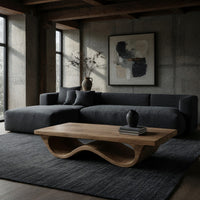 Pale hardwood coffee table with an undulating base in a concrete and timber loft
