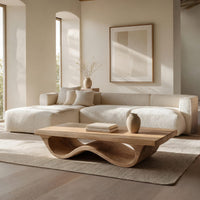 Pale hardwood coffee table with an undulating base in an open plan space in daylight