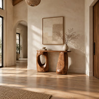 Console table with two chunky pebble shaped legs and a slim oval ended top in a bright open plan entryway