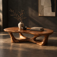Pebble shaped coffee table on branching legs with open arches, three-quarter view showing the grain