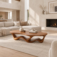 Pebble shaped coffee table with a rippling open ribbon base in a bright open plan living room