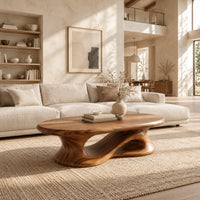 Oval coffee table on a heavy pedestal with a swirling hollow in a bright open plan living room