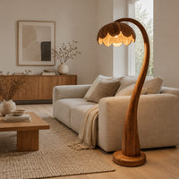 Floor lamp with a flower petal shade on a slender arching stem in a Scandinavian living room with white walls