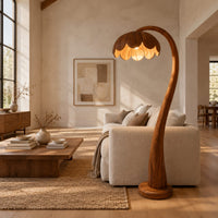 Floor lamp with a flower petal shade on a slender arching stem in a bright open plan living room