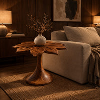End table with a carved petal top on a flaring trumpet shaped pedestal in an evening living room with walnut wall paneling