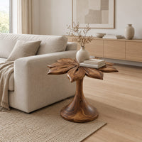 End table with a carved petal top on a flaring trumpet shaped pedestal in a Scandinavian living room with white walls
