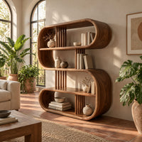 Pill shaped loop bookshelf with slatted dividers and open shelves in a bright living room with arched windows and plants