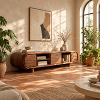 Pill shaped tv stand with open shelf bays and panel fronts in a bright living room with arched windows and plants