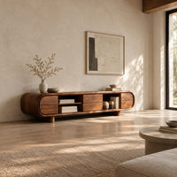 Pill shaped tv stand with open shelf bays and panel fronts in a bright open plan living room