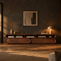 Pill shaped tv stand with three open top bays and two lower cabinets in a dark living room at golden hour