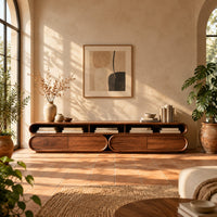 Pill shaped tv stand with three open top bays and two lower cabinets in a bright living room with arched windows and plants