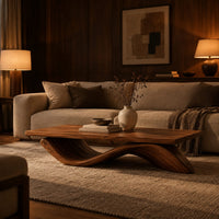Rectangular coffee table with a flat plank top on a single rolling wave base in an evening living room with walnut wall paneling