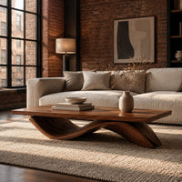 Rectangular coffee table with a flat plank top on a single rolling wave base in an industrial loft living room with exposed brick