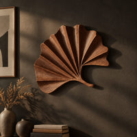 Fan shaped leaf wall art with carved radiating ridges and a curled stem, three-quarter view showing the carved depth